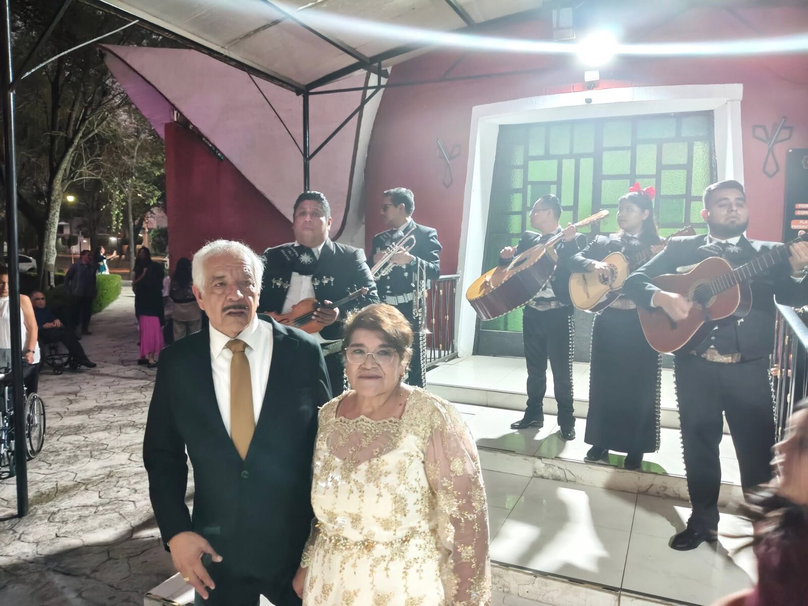 Pareja mayor con mariachi tocando de fondo por la noche