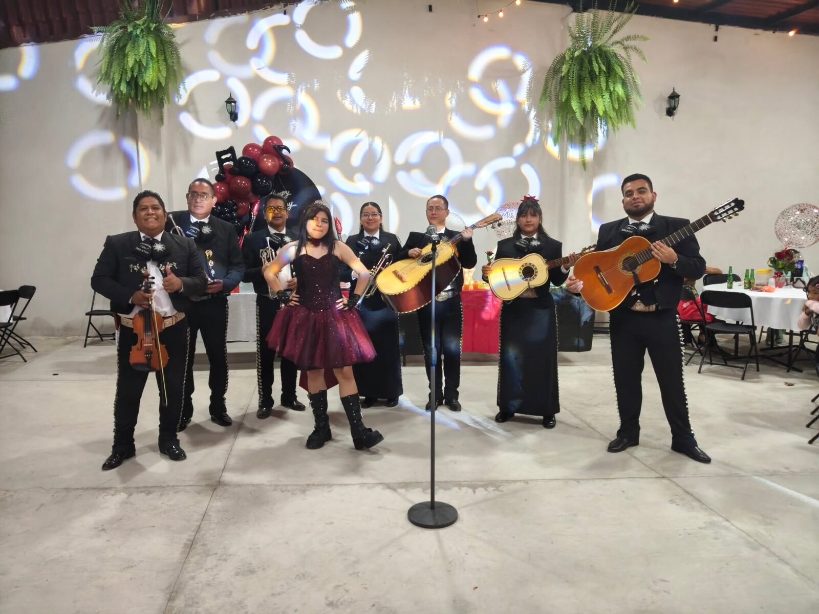 Niña festejando con mariachi en fiesta con luces